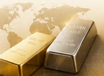 世界地図の上に置かれた金と銀のインゴット